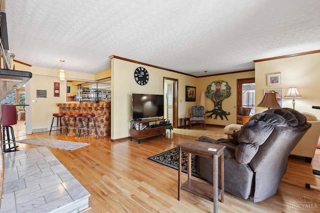600 Kathryn Dr, Wilmington, OH 45177 - living area with plenty of natural light, a textured ceiling, light wood finished floors, ornamental molding, and bar