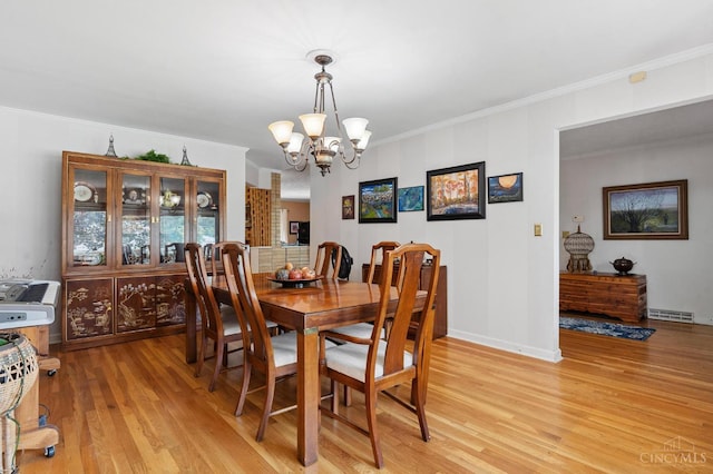 600 Kathryn Dr, Wilmington, OH 45177 - dining area with light wood-style floors, a chandelier, and ornamental molding