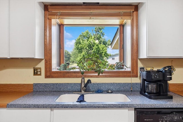 600 Kathryn Dr, Wilmington, OH 45177 - kitchen view of dishwashing machine, white cabinets, and dark countertops