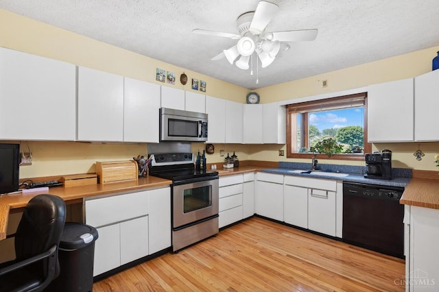 600 Kathryn Dr, Wilmington, OH 45177 - kitchen featuring appliances with stainless steel finishes, white cabinetry, light wood-type flooring, ceiling fan, and a textured ceiling