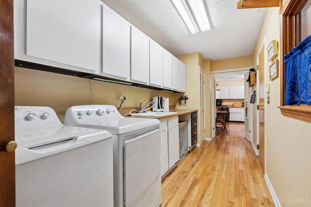 600 Kathryn Dr, Wilmington, OH 45177 - laundry room with separate washer and dryer, cabinet space, light wood finished floors, and a textured ceiling