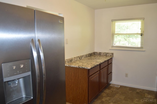 11528 Kenn Rd, Forest Park, OH 45240 - kitchen with stainless steel fridge, brown cabinets, and light stone counters