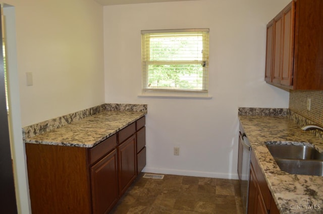 11528 Kenn Rd, Forest Park, OH 45240 - kitchen with stainless steel dishwasher, backsplash, brown cabinetry, and light stone countertops