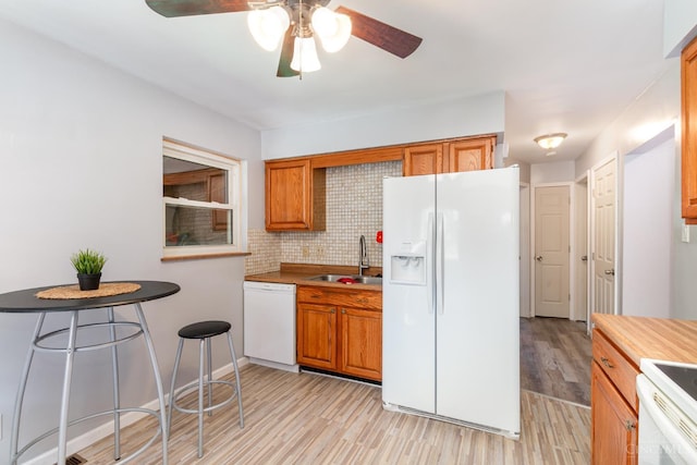 1127 Anderson Fry, Delhi Twp, OH 45238 - kitchen featuring white appliances, light wood-style flooring, ceiling fan, brown cabinets, and tasteful backsplash