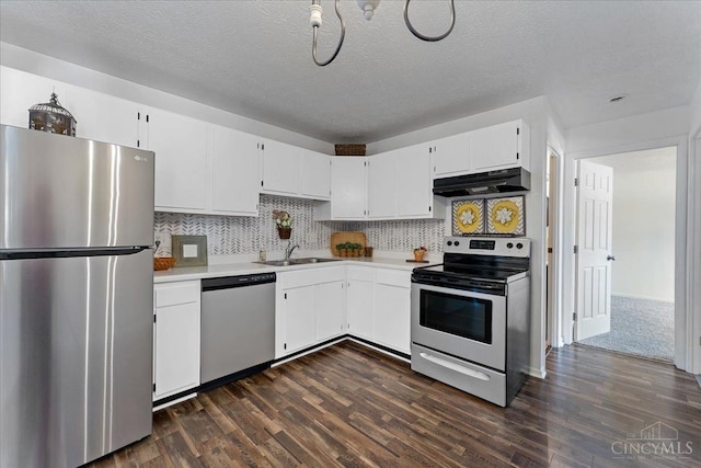 541 Davis Rd Unit 8, Pierce Twp, OH 45255 - kitchen featuring stainless steel appliances, under cabinet range hood, light countertops, dark wood-type flooring, and white cabinetry