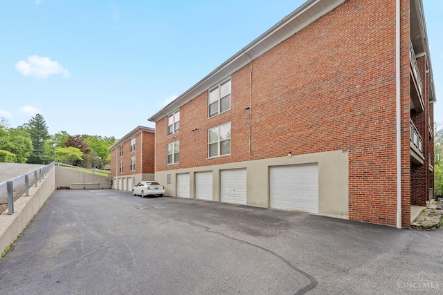3566 Amberacres Dr Unit 1, Cincinnati, OH 45237 - view of property exterior featuring brick siding, an attached garage, and asphalt driveway