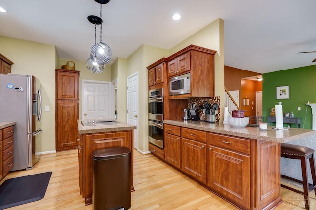 5088 Harvestdale Dr, Mason, OH 45040 - kitchen featuring stainless steel appliances, light wood-style flooring, a center island, decorative light fixtures, and recessed lighting