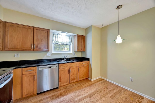 10854 Ponds Ln Unit 8, Sycamore Twp, OH 45242 - kitchen with stainless steel dishwasher, light wood-type flooring, stove, brown cabinets, and a textured ceiling