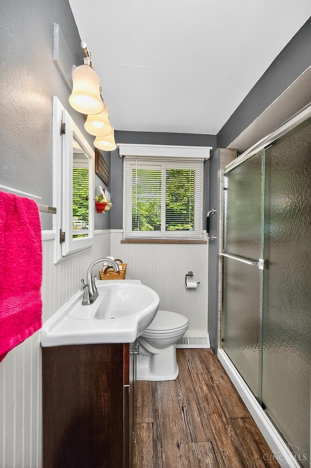 5744 Melody Ln, Milford, OH 45150 - bathroom featuring vanity, wood finished floors, a wainscoted wall, and a stall shower