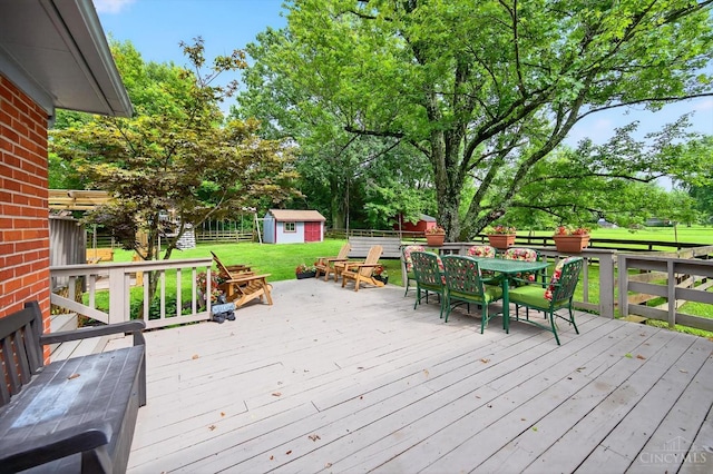5744 Melody Ln, Milford, OH 45150 - wooden terrace with outdoor dining area, a storage shed, a fenced backyard, and view of scattered trees