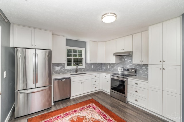2033 Jackson Ln, Middletown, OH 45044 - kitchen featuring appliances with stainless steel finishes, under cabinet range hood, dark wood-style flooring, light countertops, and a textured ceiling