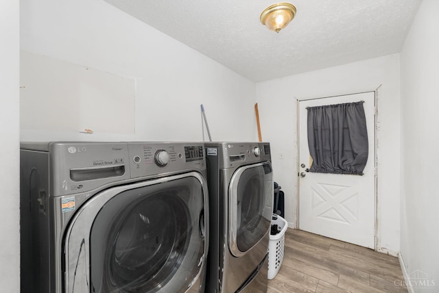 11818 Cloverlick Rd, Bethel, OH 45106 - laundry area with separate washer and dryer, light wood-style floors, and a textured ceiling