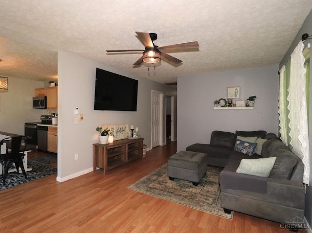 416 N Broadway St, Blanchester, OH 45107 - living area featuring a textured ceiling, ceiling fan, and light wood-type flooring
