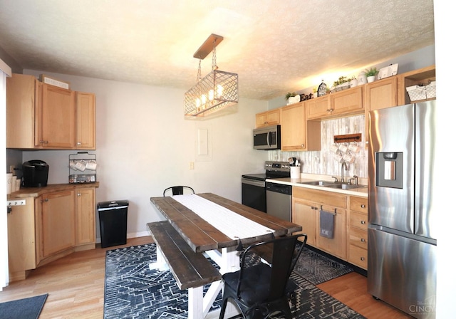 416 N Broadway St, Blanchester, OH 45107 - kitchen with stainless steel appliances, light wood-type flooring, light brown cabinetry, a chandelier, and light countertops