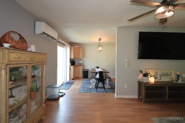 416 N Broadway St, Blanchester, OH 45107 - living area featuring a wall unit AC, light wood finished floors, and a ceiling fan