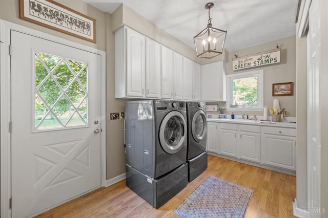 6911 Cozaddale Rd, Goshen, OH 45122 - washroom featuring washing machine and dryer, a chandelier, cabinet space, and light wood-style flooring
