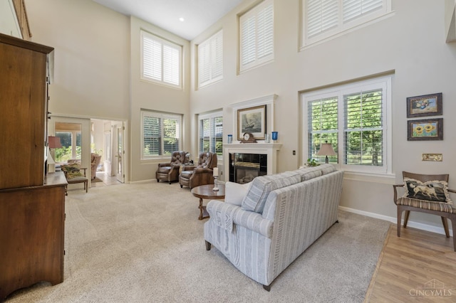 6911 Cozaddale Rd, Goshen, OH 45122 - living area featuring a high ceiling, a fireplace, and light wood finished floors