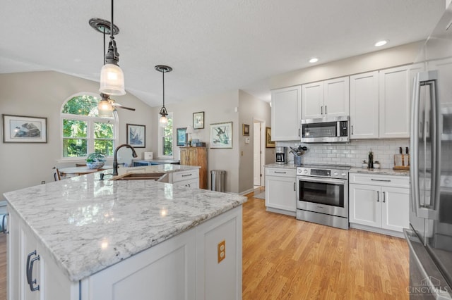 6911 Cozaddale Rd, Goshen, OH 45122 - kitchen with stainless steel appliances, light wood-style flooring, white cabinets, a kitchen island with sink, and recessed lighting
