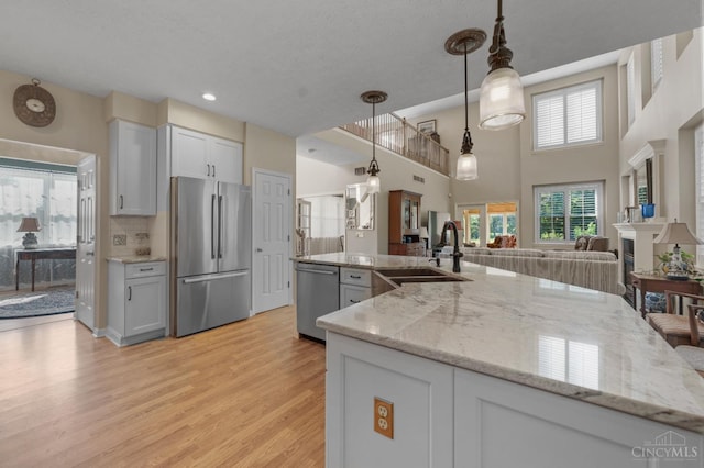 6911 Cozaddale Rd, Goshen, OH 45122 - kitchen with appliances with stainless steel finishes, light wood-type flooring, light stone countertops, open floor plan, and hanging light fixtures