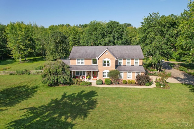 6911 Cozaddale Rd, Goshen, OH 45122 - colonial home with covered porch, a front lawn, driveway, and a forest view