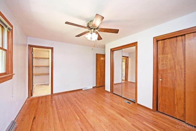 5428 Tallawanda Dr, Fairfield, OH 45014 - unfurnished bedroom with multiple closets, light wood-style floors, baseboard heating, and ceiling fan