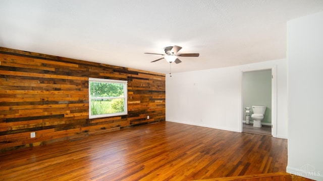 2662 Spring St, Bethel, OH 45106 - spare room featuring wooden walls, a ceiling fan, and wood finished floors