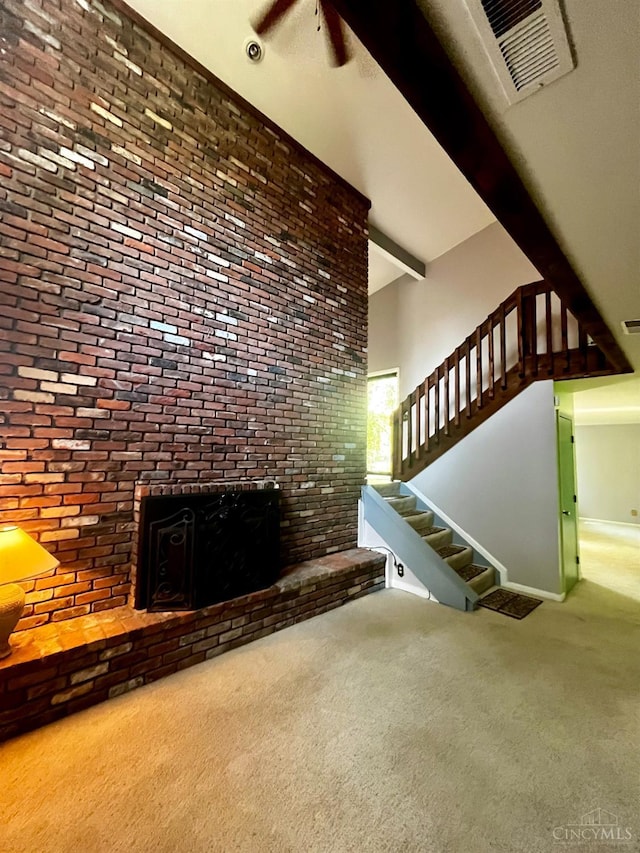 5674 Windsong Ln, Milford, OH 45150 - unfurnished living room featuring carpet flooring, beam ceiling, stairs, and a fireplace