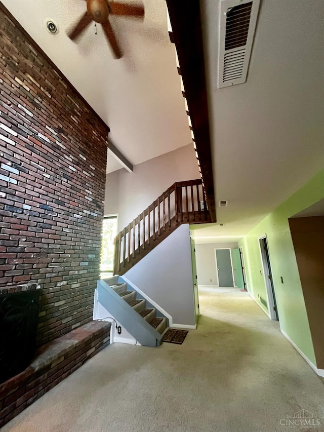 5674 Windsong Ln, Milford, OH 45150 - staircase featuring ceiling fan, carpet, and brick wall