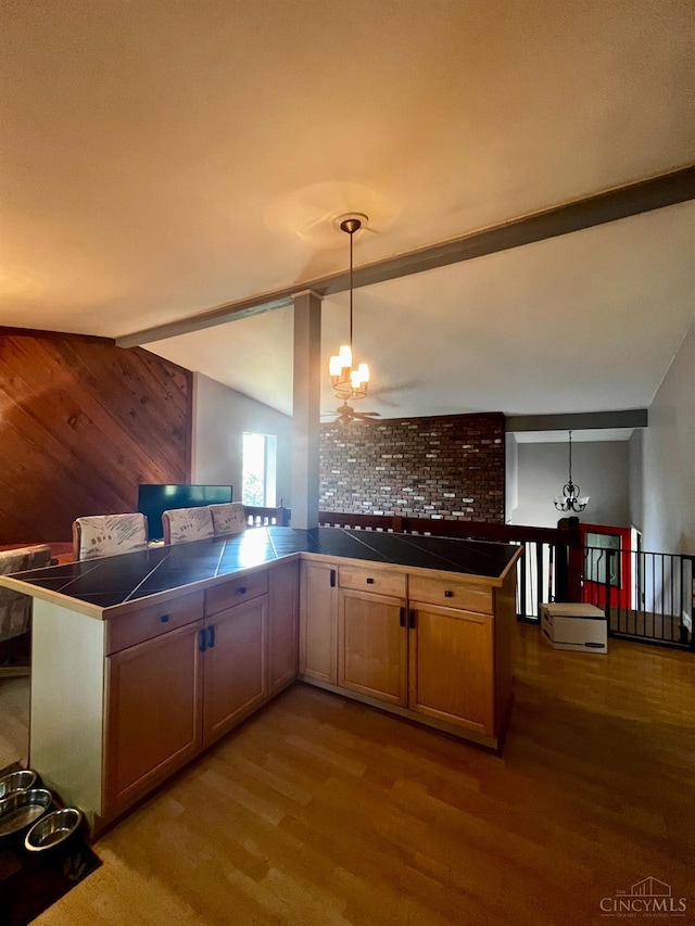 5674 Windsong Ln, Milford, OH 45150 - kitchen with dark wood-type flooring, a chandelier, tile countertops, and wood walls