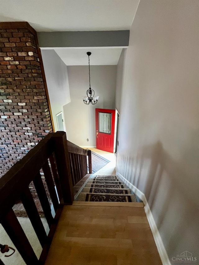 5674 Windsong Ln, Milford, OH 45150 - stairs featuring a chandelier, vaulted ceiling, and wood finished floors