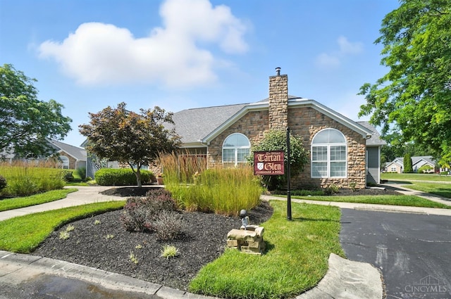 1300 Muirfield, Miami Twp, OH 45150 - view of front facade featuring stone siding, a chimney, and roof with shingles