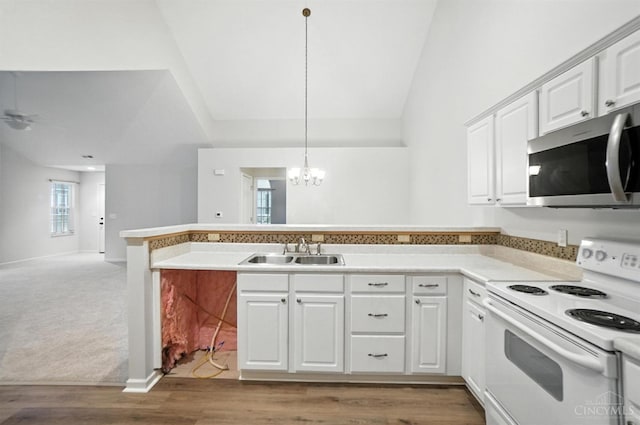 1300 Muirfield, Miami Twp, OH 45150 - kitchen featuring electric range, a peninsula, stainless steel microwave, a chandelier, and white cabinetry