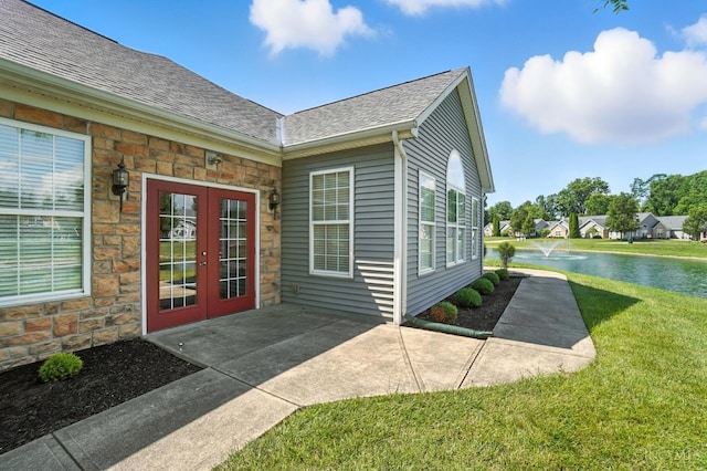 1300 Muirfield, Miami Twp, OH 45150 - entrance to property featuring french doors, a yard, a shingled roof, stone siding, and a water view
