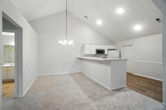 1300 Muirfield, Miami Twp, OH 45150 - kitchen featuring carpet, a peninsula, white cabinetry, high vaulted ceiling, and a chandelier