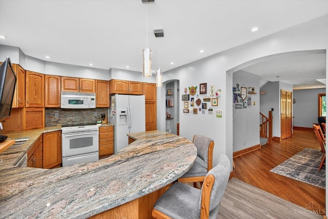 10869 Sand Run Rd, Whitewater Twp, OH 45030 - kitchen with arched walkways, white appliances, light wood-type flooring, light stone countertops, and recessed lighting