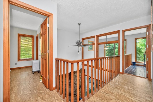 10869 Sand Run Rd, Whitewater Twp, OH 45030 - hallway featuring radiator, an upstairs landing, and a textured ceiling
