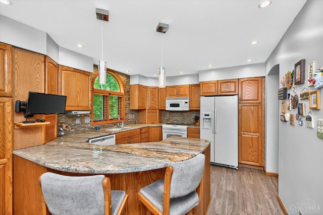 10869 Sand Run Rd, Whitewater Twp, OH 45030 - kitchen featuring white appliances, brown cabinets, a peninsula, light wood-style floors, and tasteful backsplash