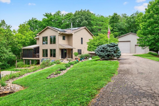 10869 Sand Run Rd, Whitewater Twp, OH 45030 - view of front of home with a sunroom, roof mounted solar panels, an outbuilding, a detached garage, and a front yard