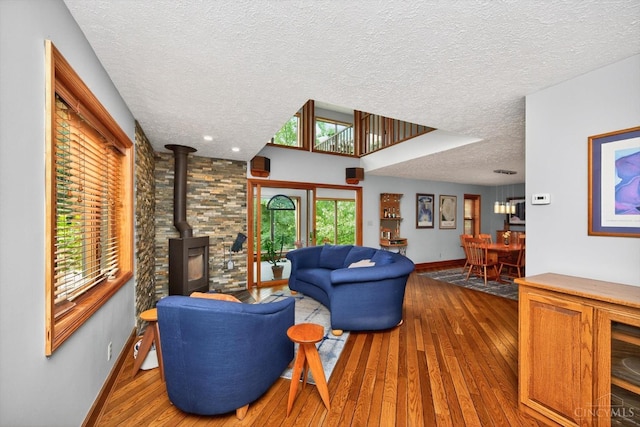 10869 Sand Run Rd, Whitewater Twp, OH 45030 - living room featuring a wood stove, a textured ceiling, and hardwood / wood-style floors