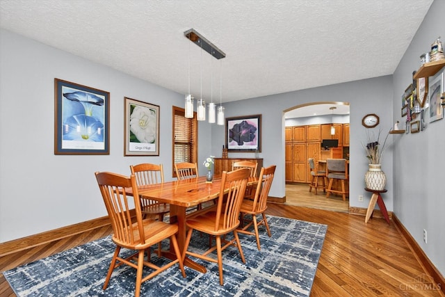 10869 Sand Run Rd, Whitewater Twp, OH 45030 - dining area featuring arched walkways, a textured ceiling, and light wood-type flooring