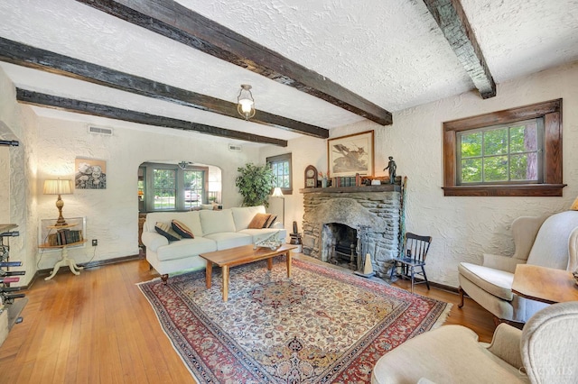 799 Millville Oxford Rd, Hamilton, OH 45013 - living area with a textured wall, plenty of natural light, arched walkways, a fireplace, and beamed ceiling