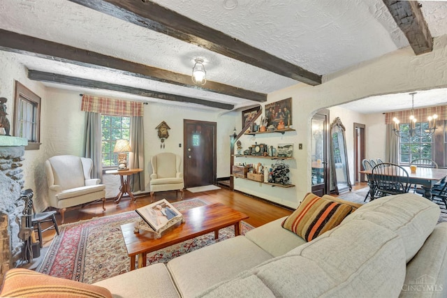 799 Millville Oxford Rd, Hamilton, OH 45013 - living area with a chandelier, wood finished floors, beamed ceiling, a textured ceiling, and arched walkways