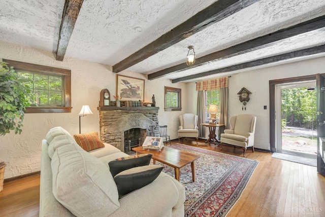 799 Millville Oxford Rd, Hamilton, OH 45013 - living area with a textured wall, healthy amount of natural light, a stone fireplace, wood finished floors, and beamed ceiling