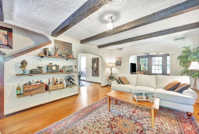 799 Millville Oxford Rd, Hamilton, OH 45013 - living area featuring arched walkways, wood finished floors, beam ceiling, and a textured ceiling