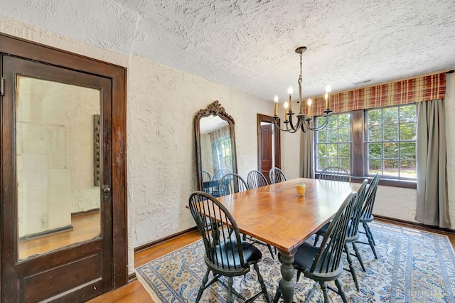 799 Millville Oxford Rd, Hamilton, OH 45013 - dining room featuring a textured wall, a textured ceiling, a chandelier, and wood finished floors