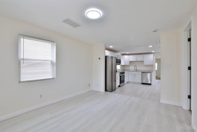 841 Willow Ave, Hamilton, OH 45013 - kitchen with light wood-style flooring, appliances with stainless steel finishes, light countertops, white cabinetry, and open floor plan