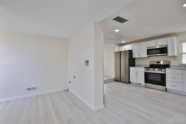 841 Willow Ave, Hamilton, OH 45013 - kitchen featuring appliances with stainless steel finishes, light wood finished floors, white cabinets, light countertops, and recessed lighting