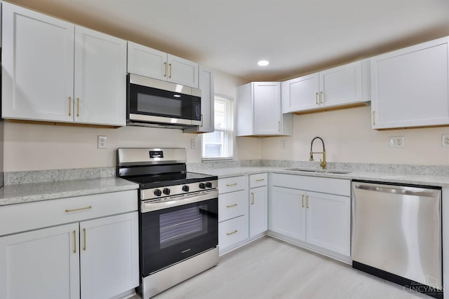 841 Willow Ave, Hamilton, OH 45013 - kitchen with stainless steel appliances, white cabinets, recessed lighting, and light wood-style floors