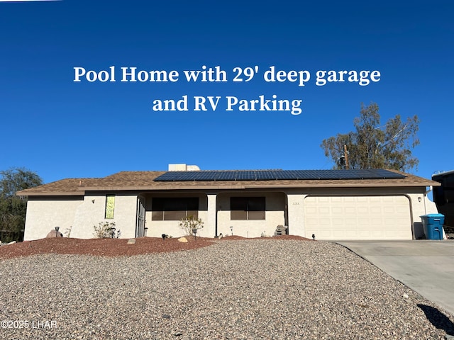 single story home featuring an attached garage, solar panels, concrete driveway, and stucco siding