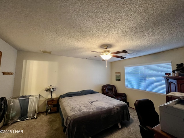 carpeted bedroom featuring ceiling fan, a textured ceiling, and visible vents